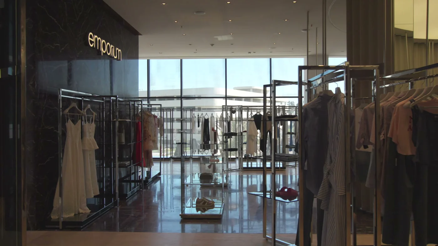 Витрина универмага Emporium внутри Lighthouse Mall и стеклянная стена молла