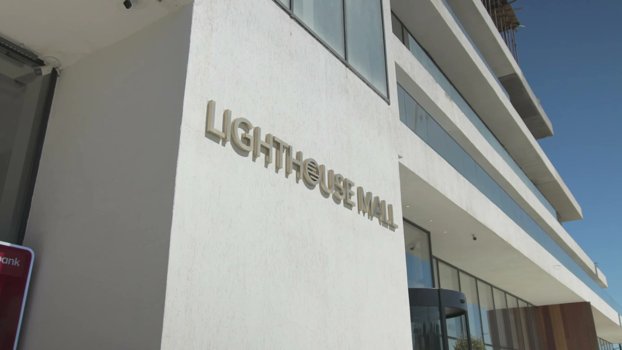 Ticarət mərkəzinin fasadında Lighthouse Mall lövhəsi — boulinq klubu bu binanın içində işləyir